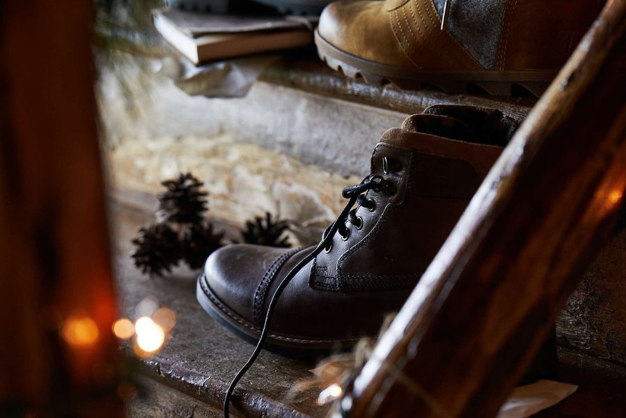 Black boots on rustic wooden stairs shot through the banister. Fashion lifestyle photography for The Buckle.