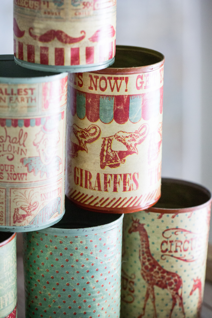 Closeup event photography of cans covered in vintage circus paper for a carnival game. 