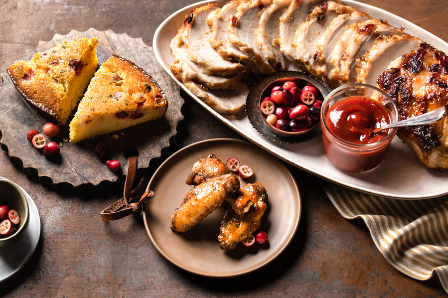 A creative food photography image featuring delicious cranberry recipes. Taken by a skilled food photographer, the photo showcases a beautiful spread of cranberry dishes on a wooden table. 
