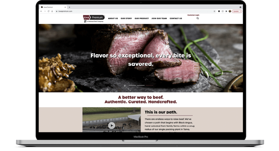 Laptop mockup with meat photography website banner image with medium steak beautifully cut and laid out on a slate surface 