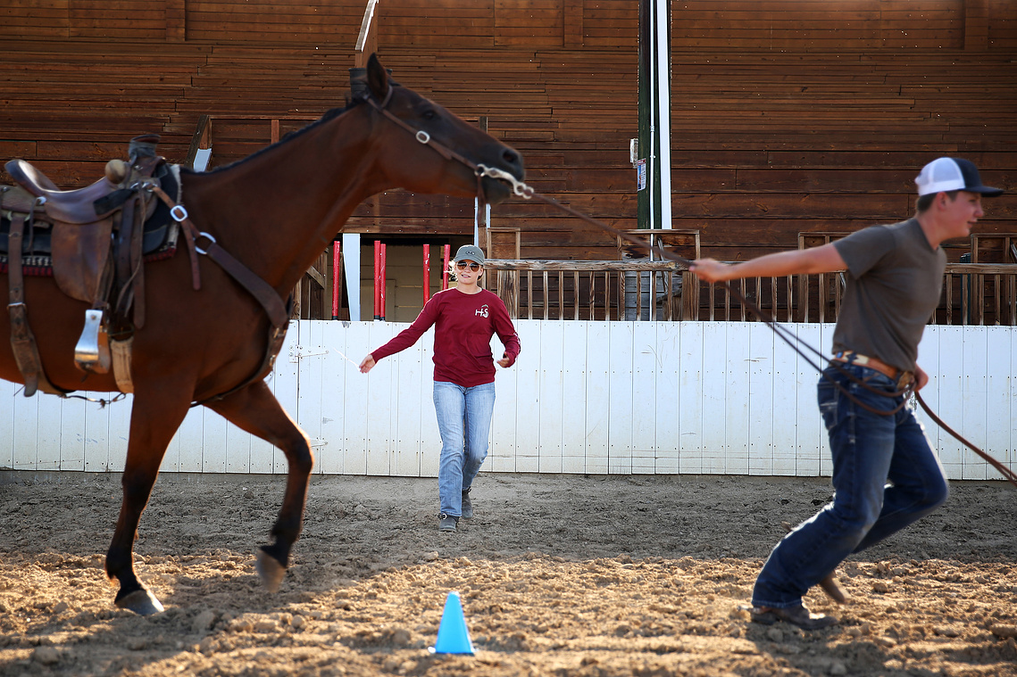 Elsa clicks and waves her arms to help Grady Alger bring his horse up to a jog during his practice showmanship pattern on July 6, 2020. Elsa taught the showmanship section of the Monday night horse classes this year, teaching kids proper techniques.