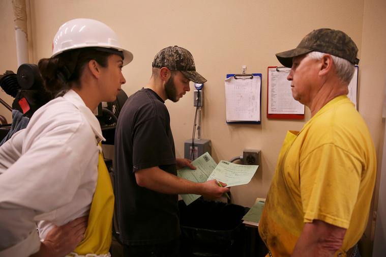 Brandon Purcella, right, talks with James Miller and inspector Vanessa Gall about future scheduling. They received a number of animals to be state inspected and were figuring out when Vanessa would need to come back after the two week hang time.