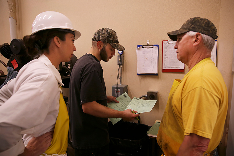 Brandon Purcella, right, talks with James Miller and inspector Vanessa Gall about future scheduling. They received a number of animals to be state inspected and were figuring out when Vanessa would need to come back after the two week hang time.