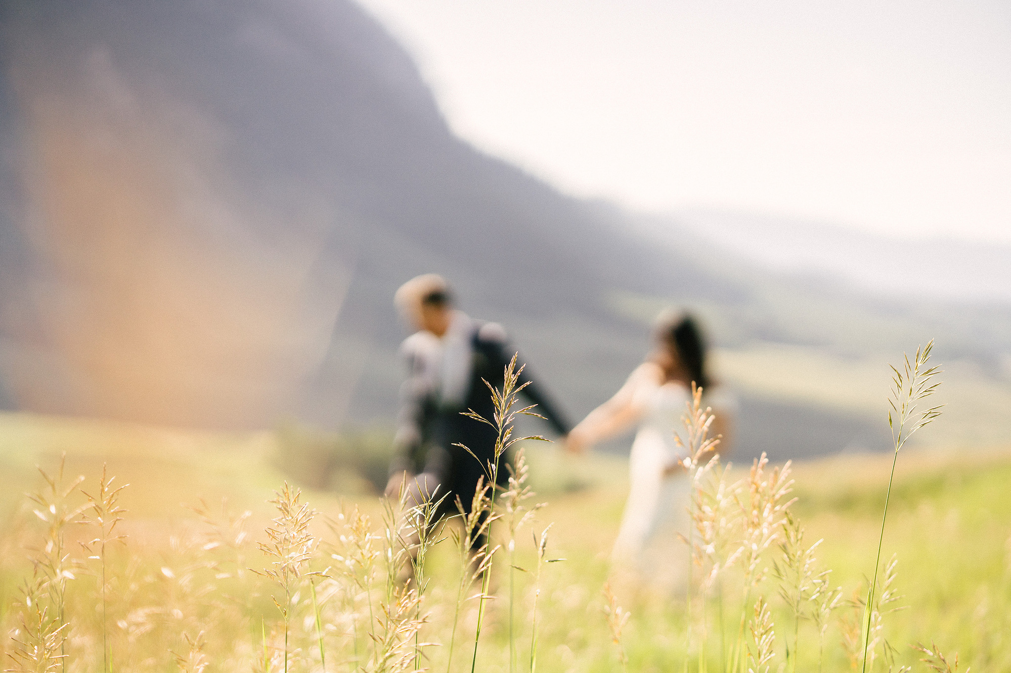 Crested Butte elopement in Colorado with a couple walking through a wildflower meadow and soft mountain light