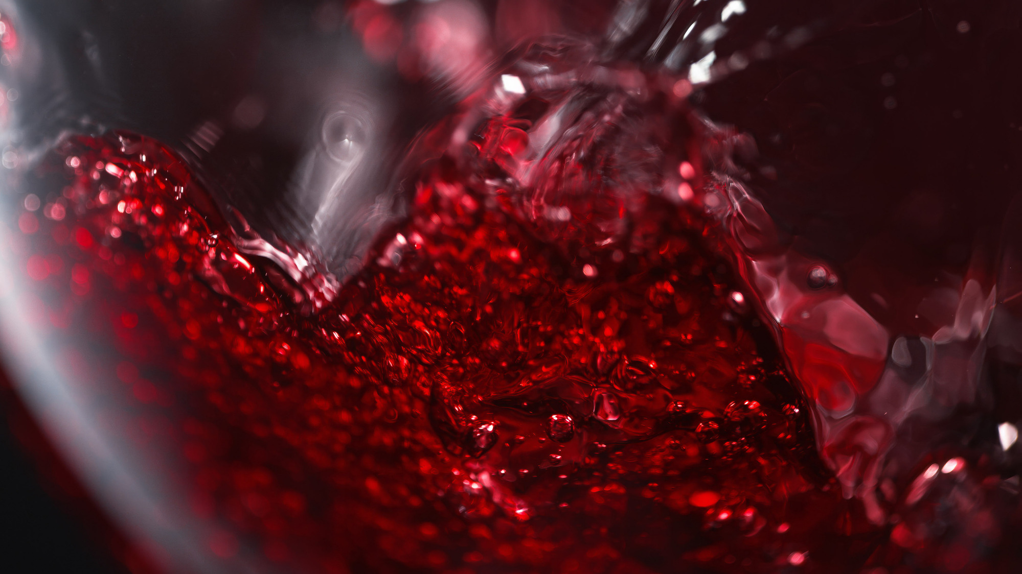 Advertising photography by Timothy Hogan of Banfi Estate Belnero Super Tuscan wine pouring into a glass on a black background. 