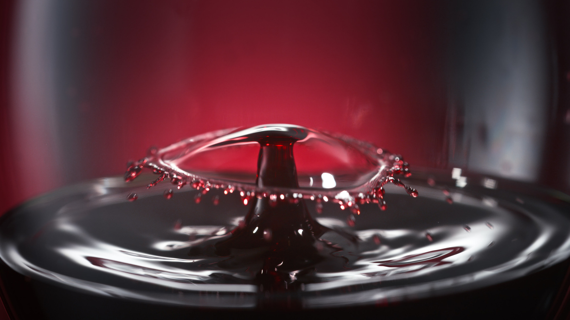 Macro advertising photography by Timothy Hogan of Banfi Estate Belnero Super Tuscan wine on a red background. 