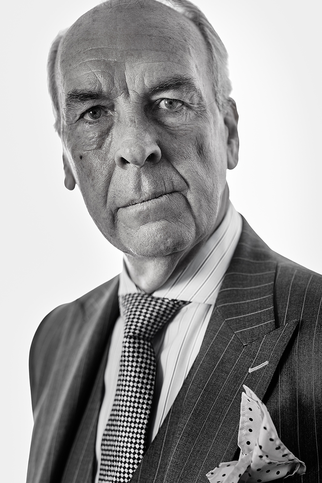 Black and white corporate portrait of an elderly businessman photographed in Matt Keal's Norwich photographic studio. Shot by Norwich commercial, freelance portrait photographer Matt Keal.