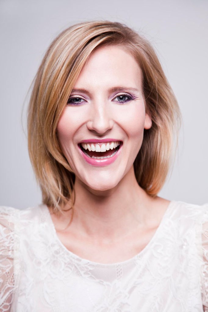 Corporate headshot of blonde, female employee laughing and looking into the camera in a photography studio. Shot by Norwich commercial, freelance portrait photographer Matt Keal.