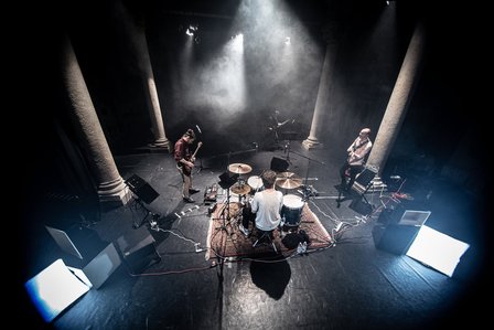 a view from above of a concert stage with instruments and musicians, smoke in the room is creating a hazy view