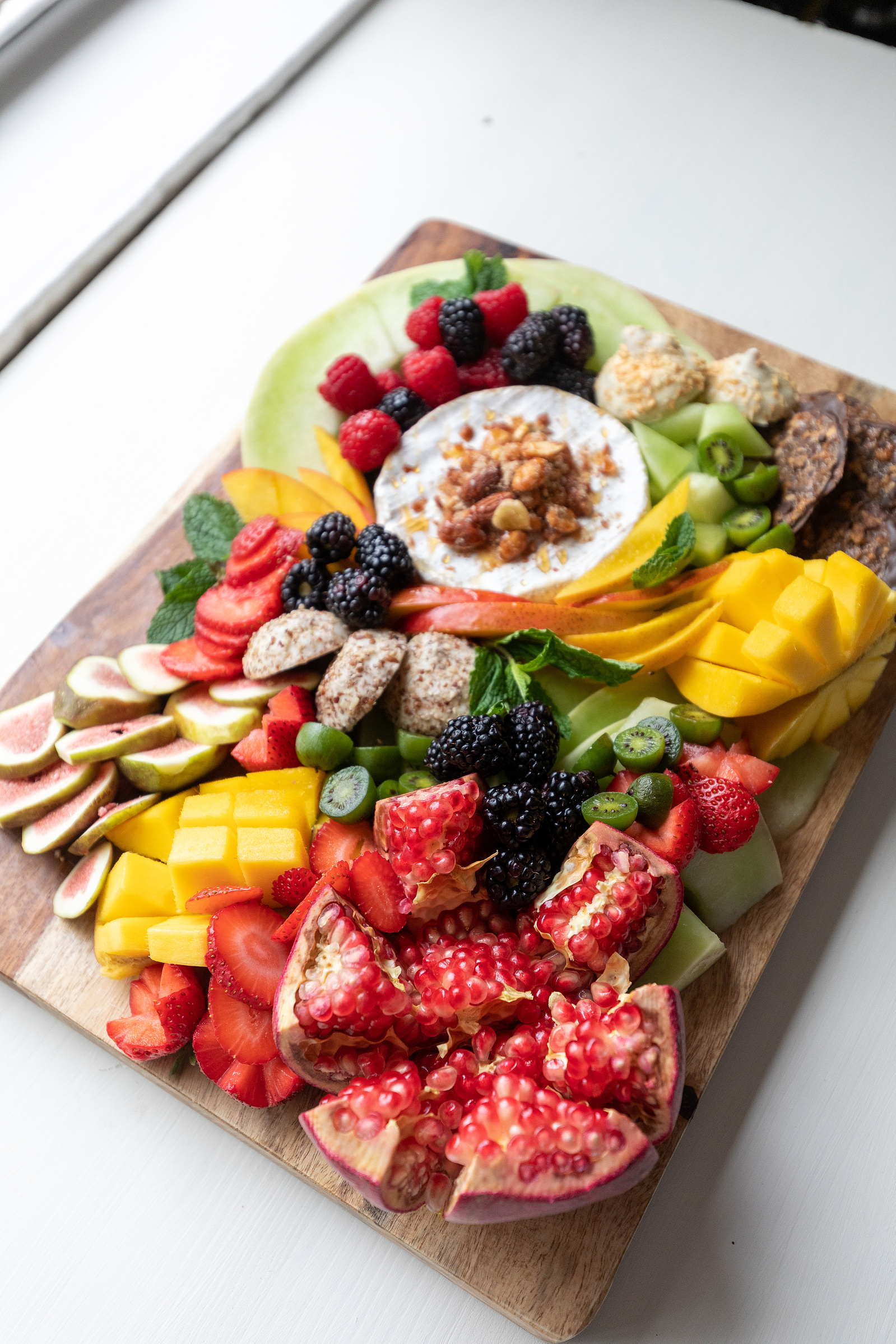 thegrazenc.com small board shot on wood in Wilmington, NC. fruits and vegetables arranged artistically for group gatherings and snacking.