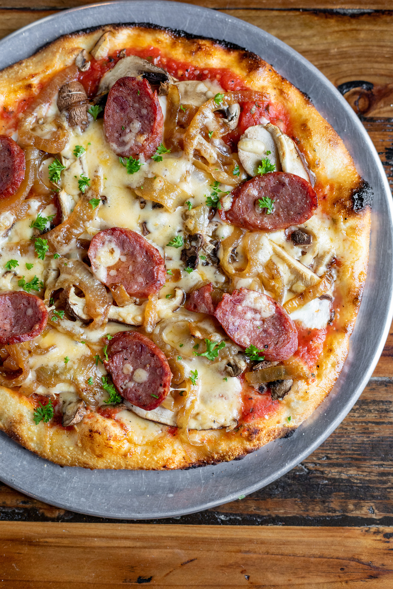 The Pizza Hyena || sausage, cheese, pizza, overhead, magazine, commercial food photography, red, yellow, brown, wooden table