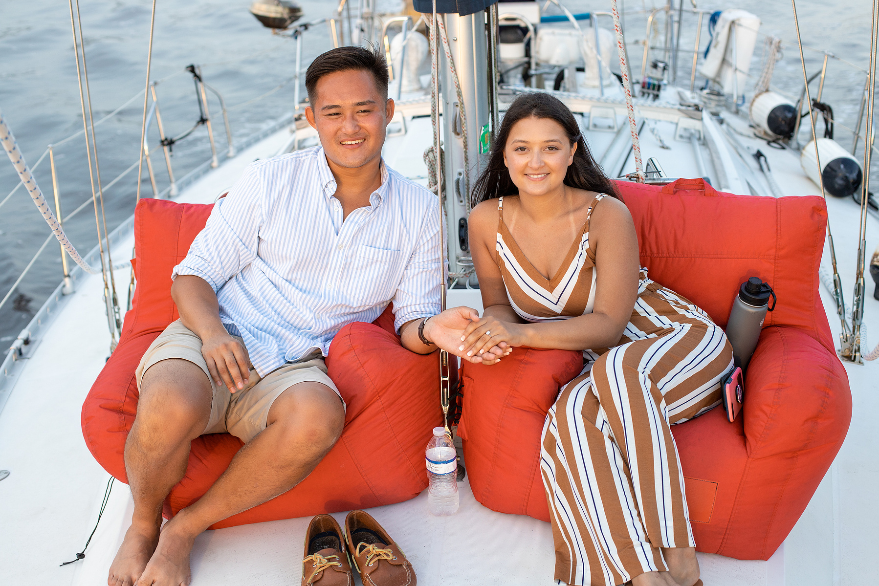 couple, sitting, sailboat engagement, happy couple, poses, relaxing, red, white, no shoes