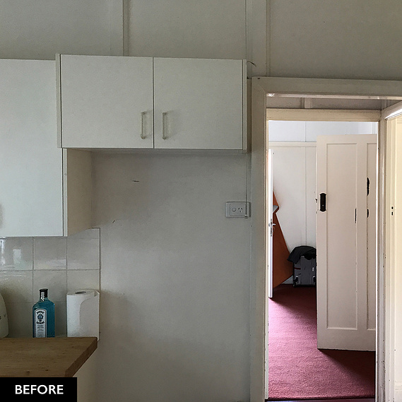 White cupboards and a maroon carpet on the interior of a house before renovation