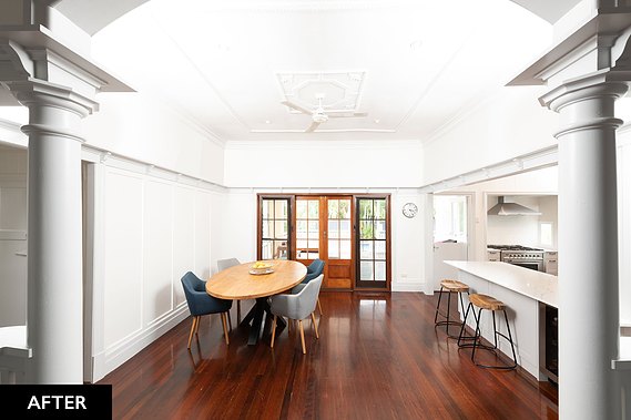 White, open concept kitchen with wooden barstools and floors