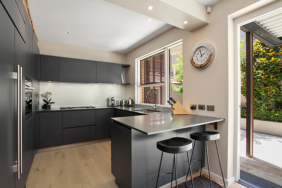 Kitchen with black cupboards and countertops and minimalistic decor