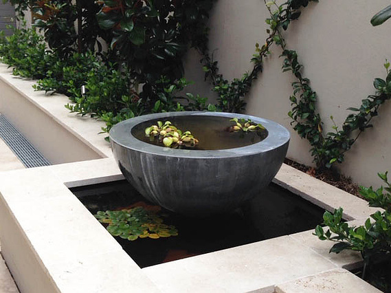 Exterior design half sphere fountain feature with floating plants