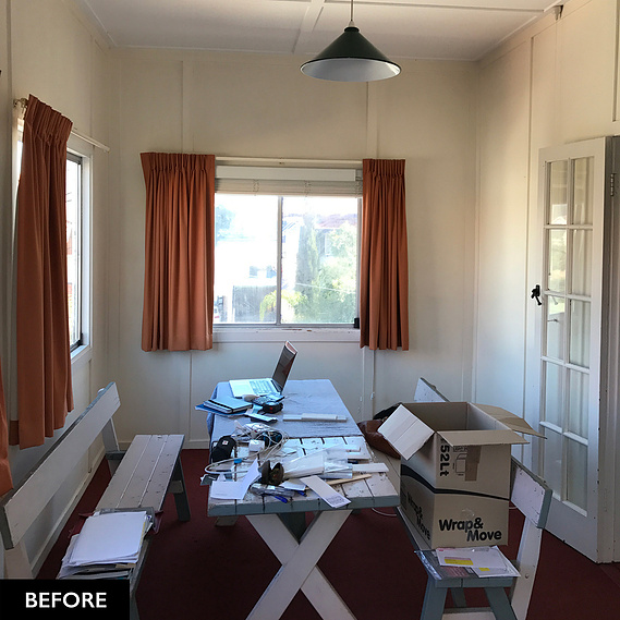 Cluttered dining room table with orange curtains