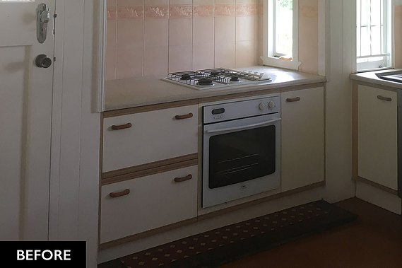 Old gas stove with outdated white kitchen cupboards