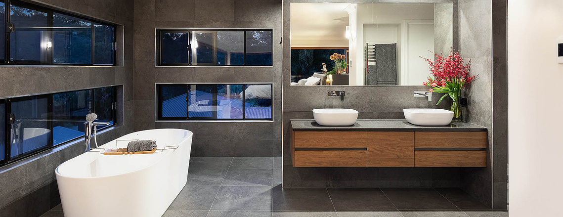 Grey slate bathroom with white bathtub 