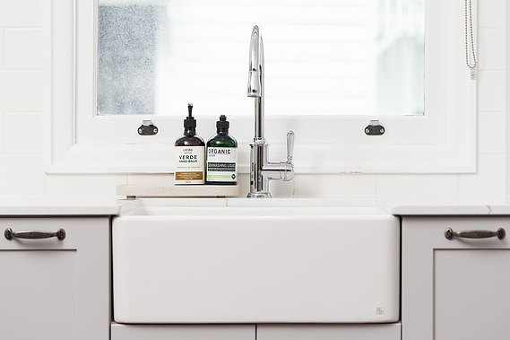 Modern, white kitchen sink next to a window