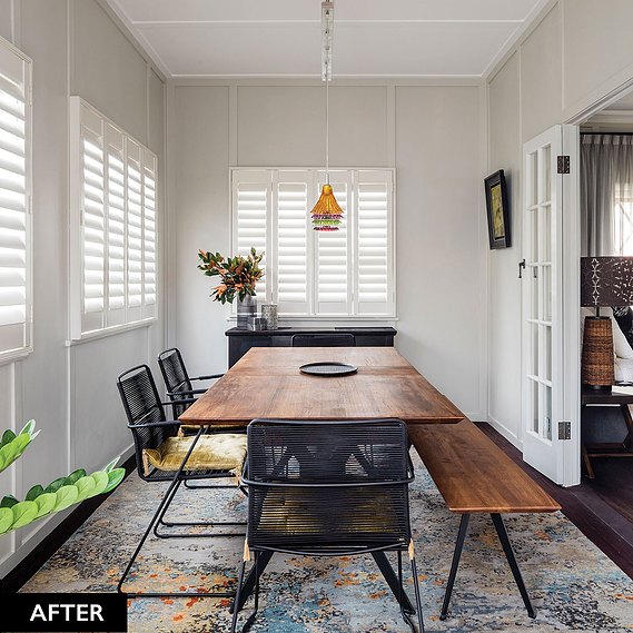 Modern wooden dining room table with trendy black chair, colourful hanging lamps and white shutter