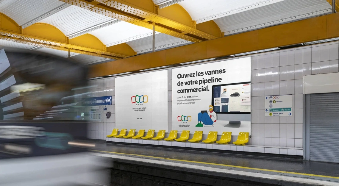 Double panneau publicitaire 4x3 dans le métro de Paris : logo ZOHO associé à une illustration d'un personnage travaillant sur un ordinateur portable. Création illustration : Clemence Thune
