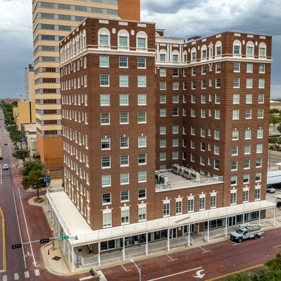 Drone photograph of, background, Metro Tower, foreground dark brick is the Pioneer Pocket Hotel, Lubbock, Texas