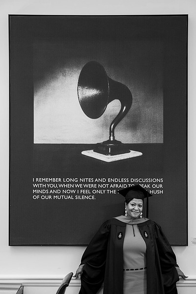 A business school graduate in from of a wall poster, Boston