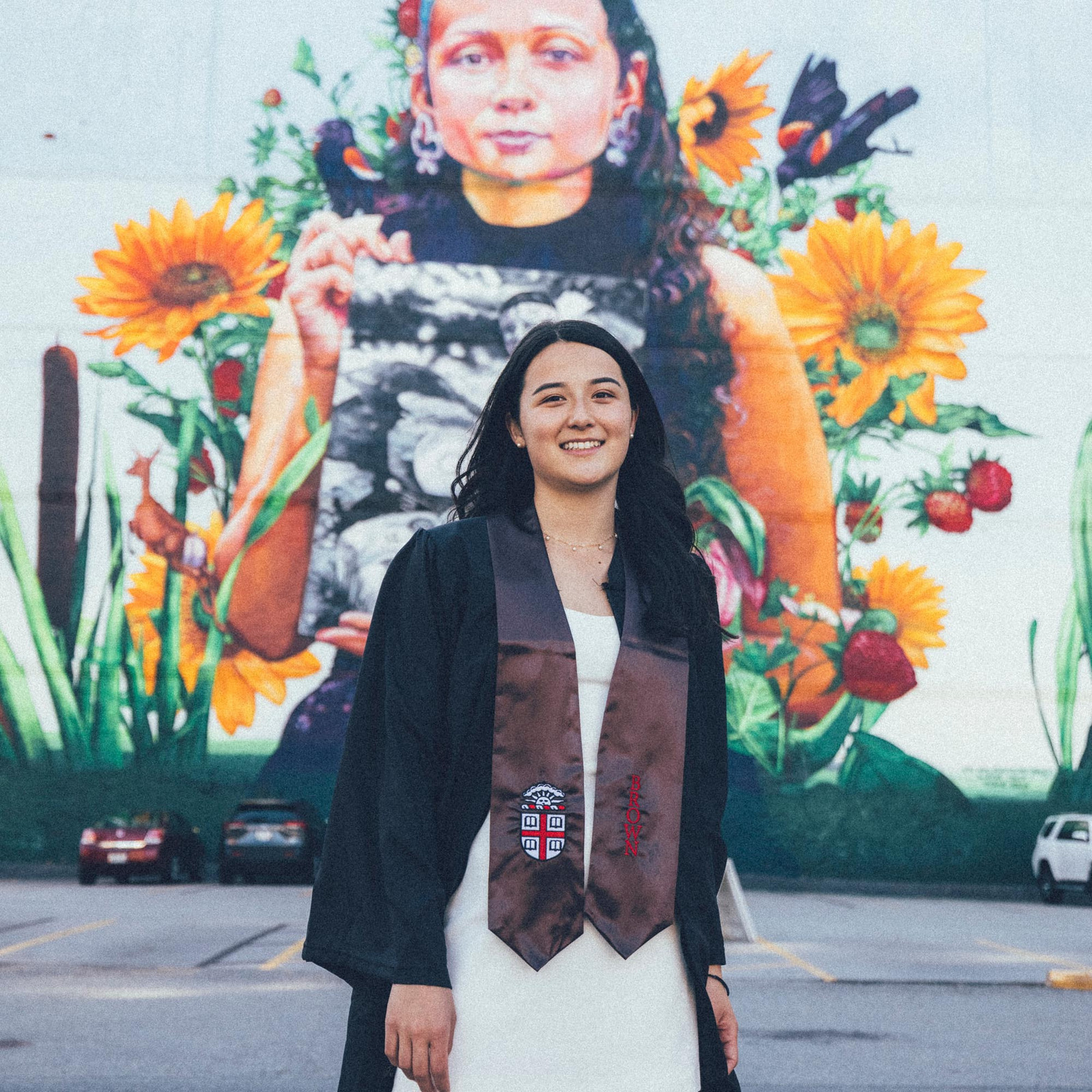 Brown University graduate in front of a mural in Providence, RI