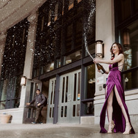 A graduate with a bottle of champagne in front of  Suffolk law school, Boston, MA