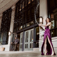 A graduate with a bottle of champagne in front of  Suffolk law school, Boston, MA