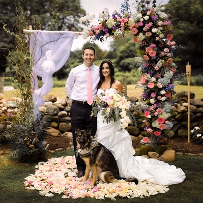 Newly married couple is posing with a dog and flowers. Connecticut. Photographer Ivan Djikaev/Mind On Photography.
