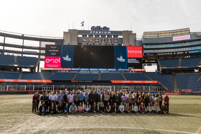 A photo of a large group of professionals on the Gillette stadium field