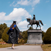 University graduate in front of George Washington statue in Boston Public garden 