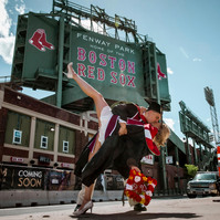 Couple celebrating college graduation in front of Red Sox Sign, Fenway Park, Boston, MA
