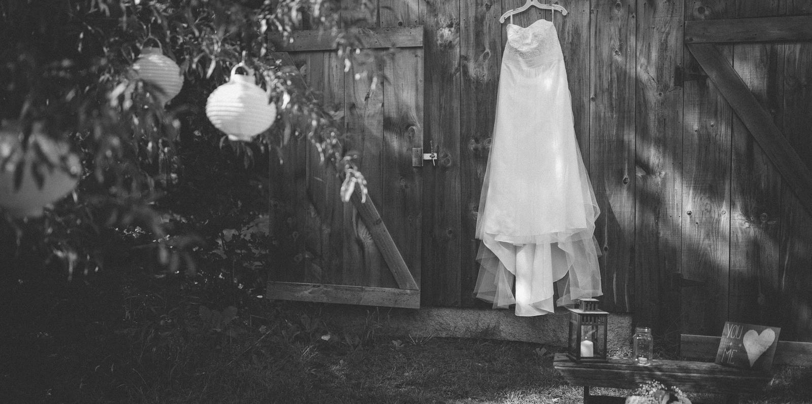 Boho wedding dress and other wedding decorations hanging on a barn wall