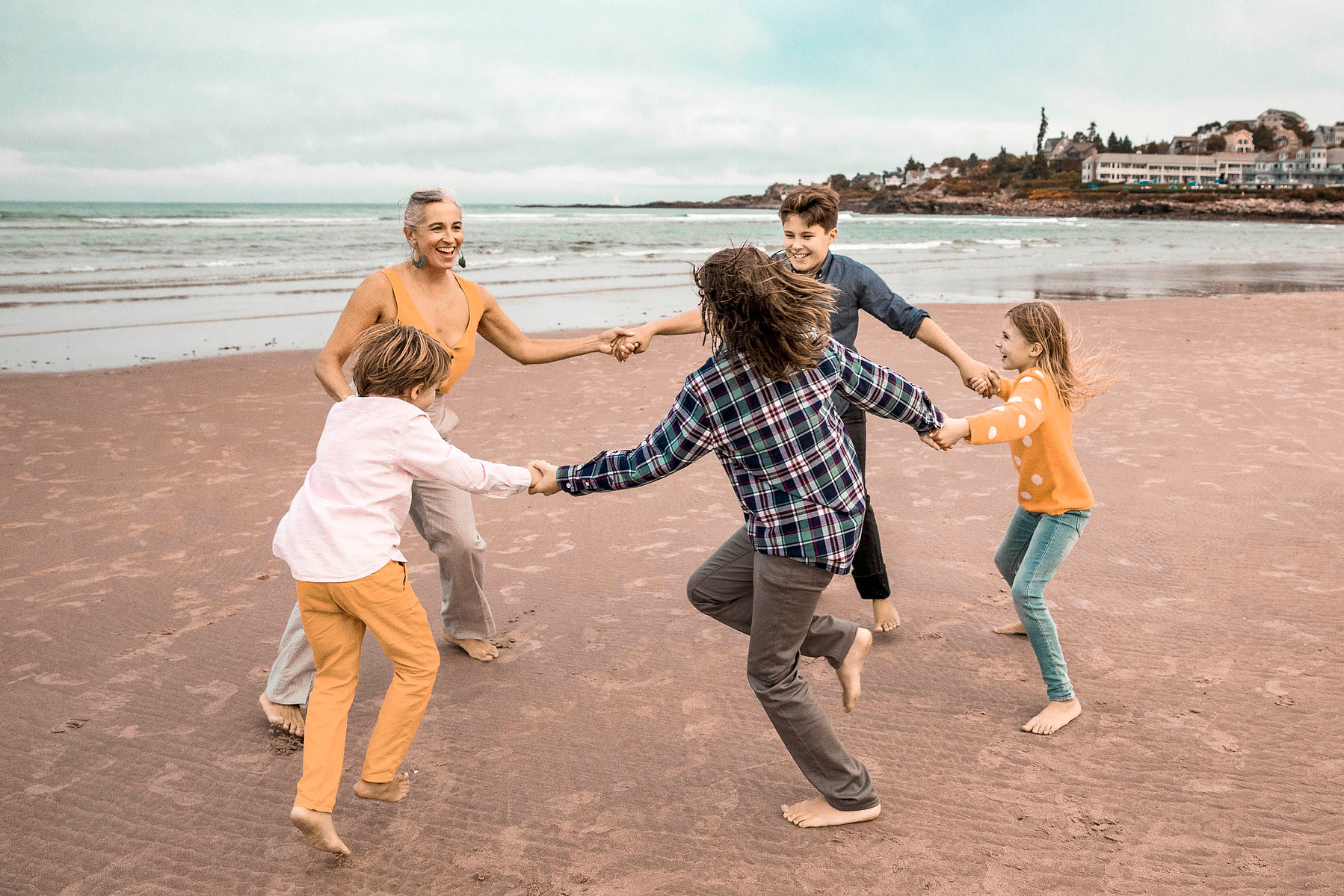 family dancing on a beach