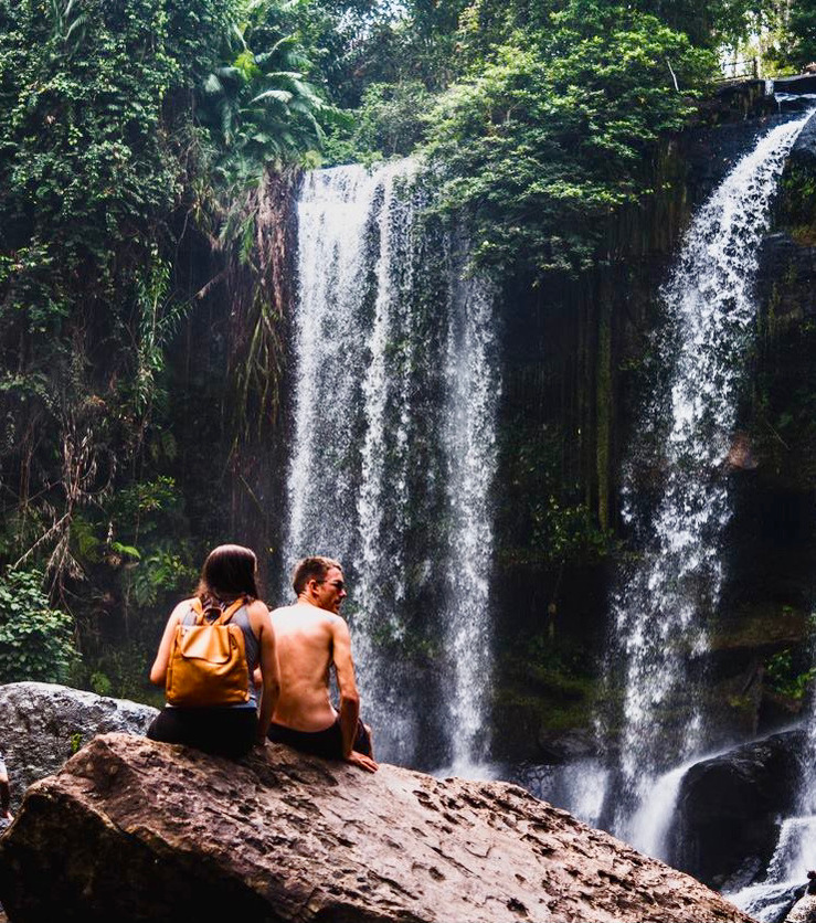 A to be married couple enjoying together near a waterfall