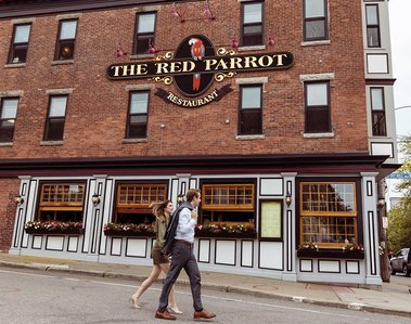 A Couple walking in front of The Red Parrot restaurant in Newport, RI. Photographer Ivan Djikaev/Mind On Photography.