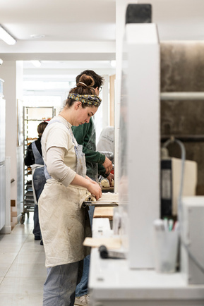 Boulangère en train de façonner des baguettes traditions dans son laboratoire à Paris
