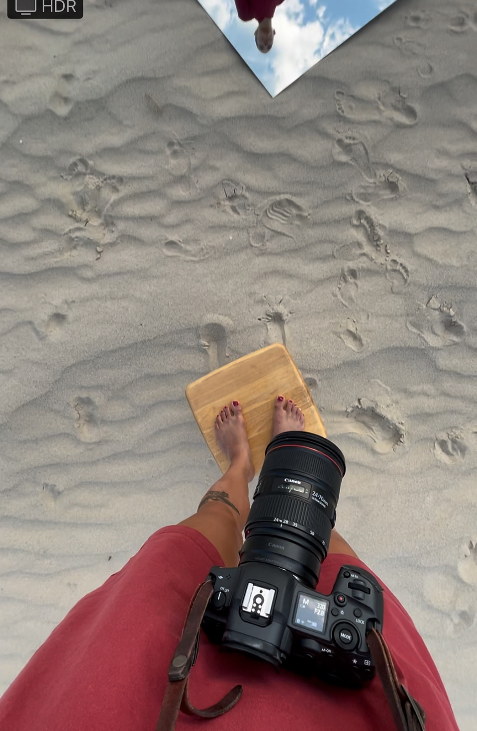behind the scenes photo of a portrait session with Cari Faye photography at the Seminole sand dunes in casper Wyoming. Cari Faye Antonovich is photographed here standing on top of a stool to get a better vantage point of her subject, a Buddhist monk.