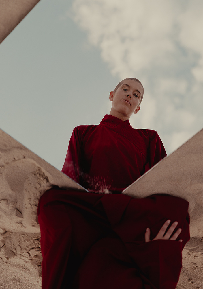 a buddhist monk in a red robe photographed by Cari Faye Antonovich of The White Room Studios at the Seminoe sand dunes near Rawlins Wyoming at sunset with a mirror