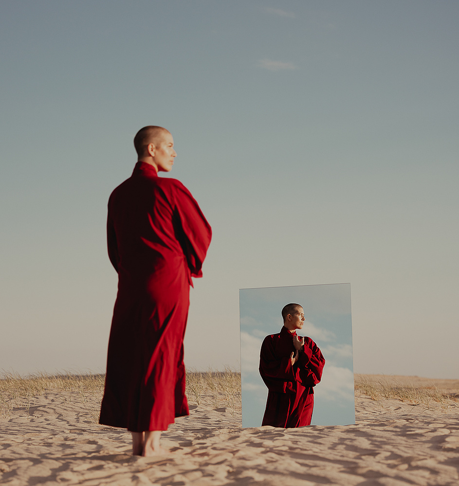 a buddhist monk in a red robe photographed by Cari Faye Antonovich of The White Room Studios at the Seminoe sand dunes near Rawlins Wyoming at sunset with a mirror