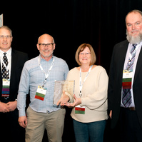 Four people stand on stage, receiving an award, at the 2025 Associated General Contractors (AGC) annual conference