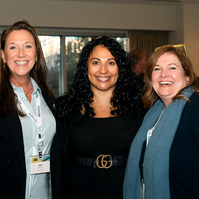 Three smiling woman pose for a photograph