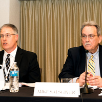 Two businessmen, on the board of directors, sit at a table addressing an audience during the 2025 AGC Annual Conference in Oregon
