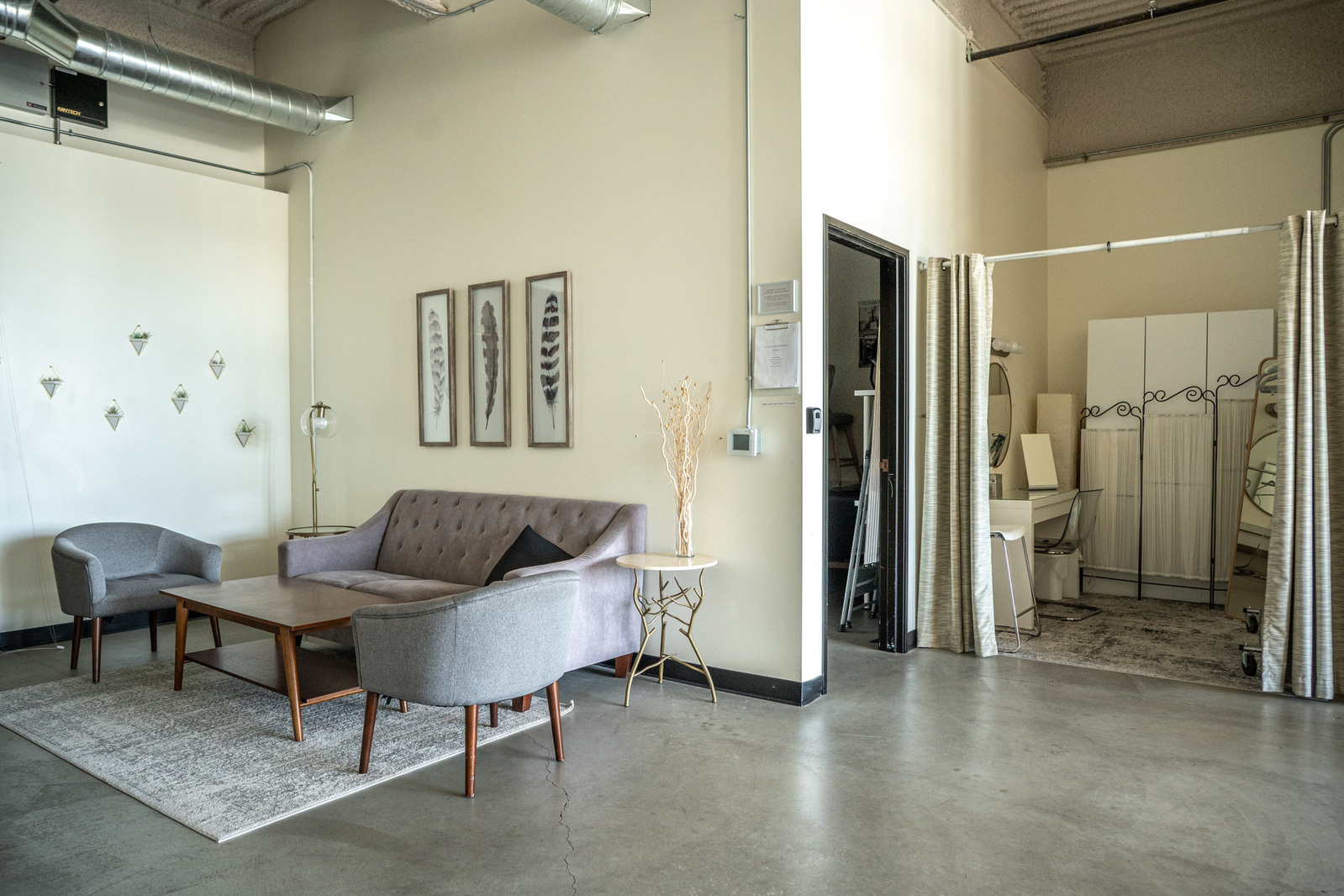 Welcome area with couches, table and a dressing room in a natural light studio