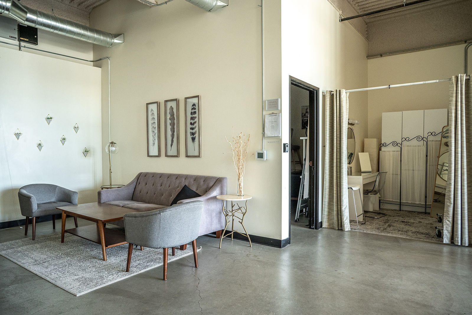 Welcome area with couches, table and a dressing room in a natural light studio