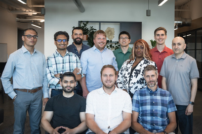 A large group of employees pose for a group work photo