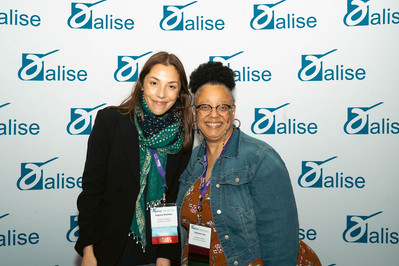 Two women with their awards in front of the ALISE step and repeat